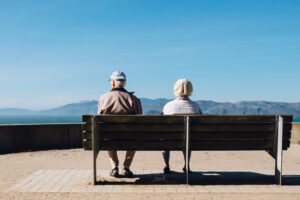 two people sitting on bench overlooking mountains annuities