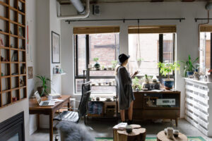 woman standing in business in front of windows with wooden cabinets