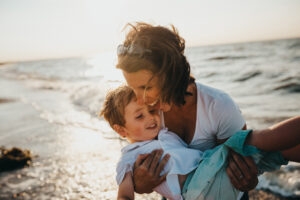 woman carrying child on beach life insurance